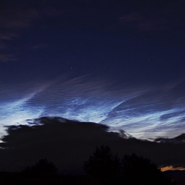 Noctilucent clouds in the night sky.