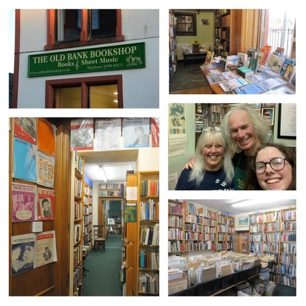 The Old Bank Bookshop Wigtown. Proprietors Ian and Joyce Cochrane and their daughter. The outside signage and various bookshelves full of books and sheet music.