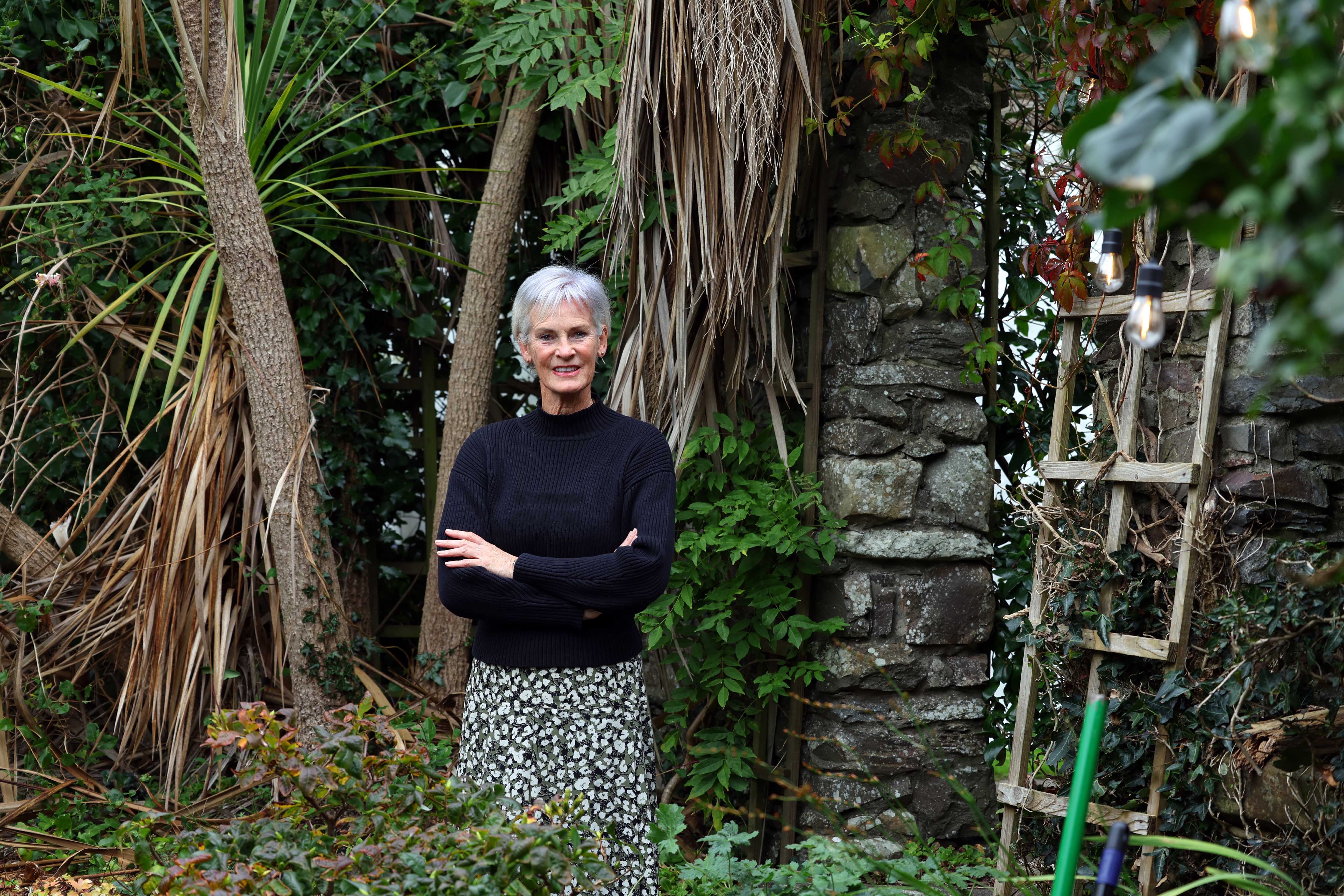 Judy Murray stands, arms crossed, in a garden.