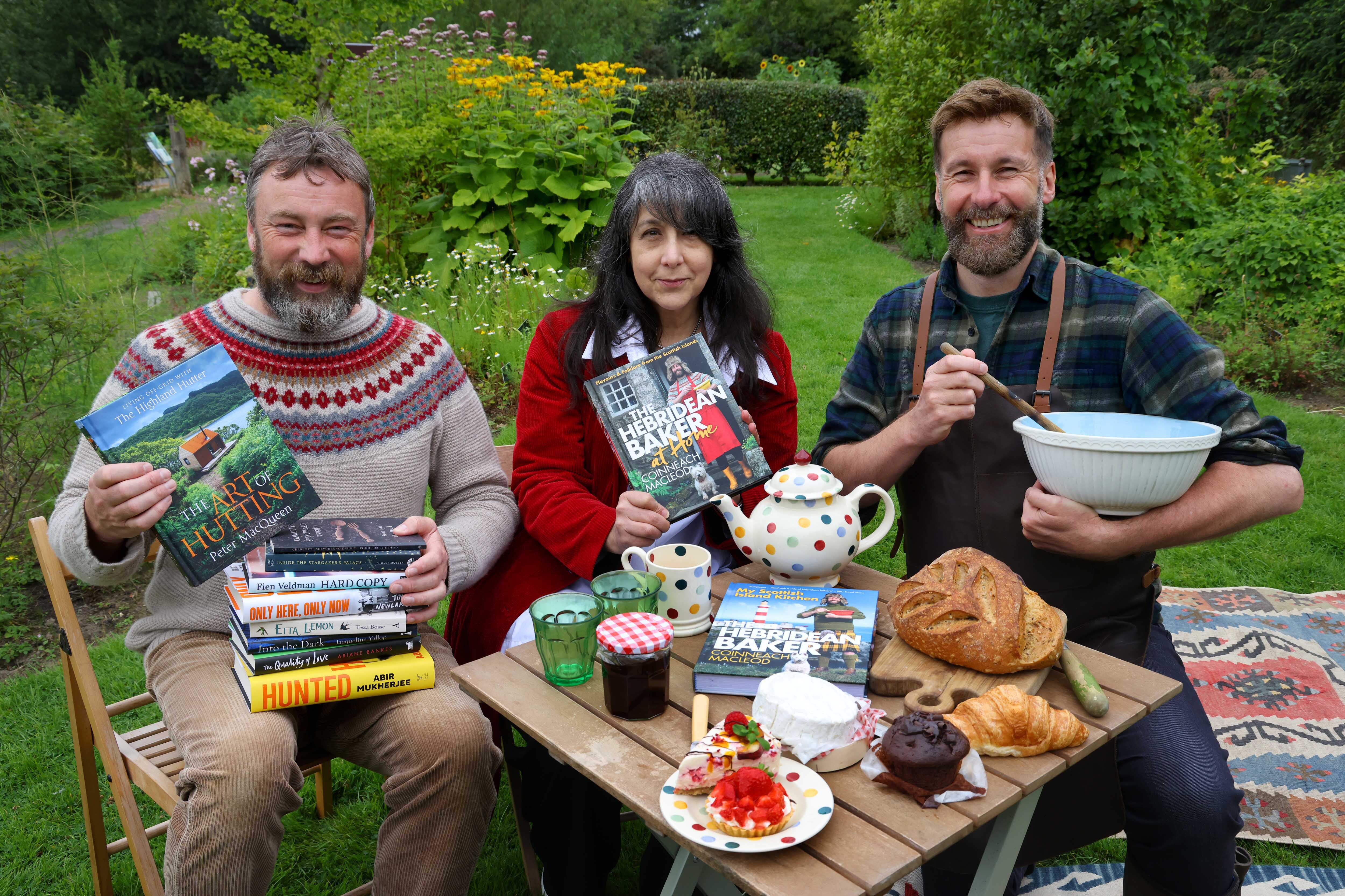 WBF 2024 Programme Launch PR image. Lee Randall, Peter MacQueen and Coinneach MacLeod at a picnic with baked goods and books.