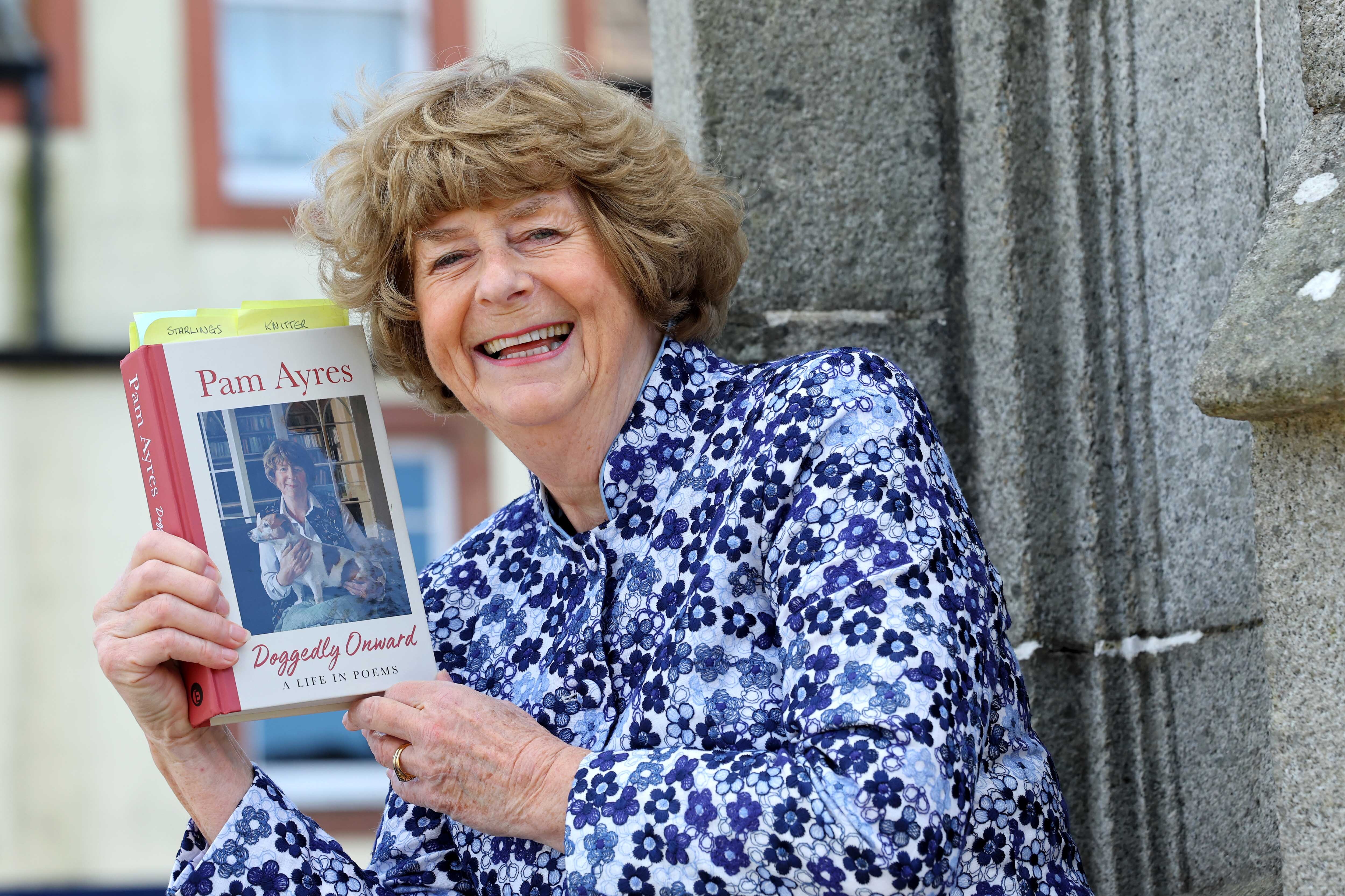 Pam Ayres outside the county buildings, holding her new book