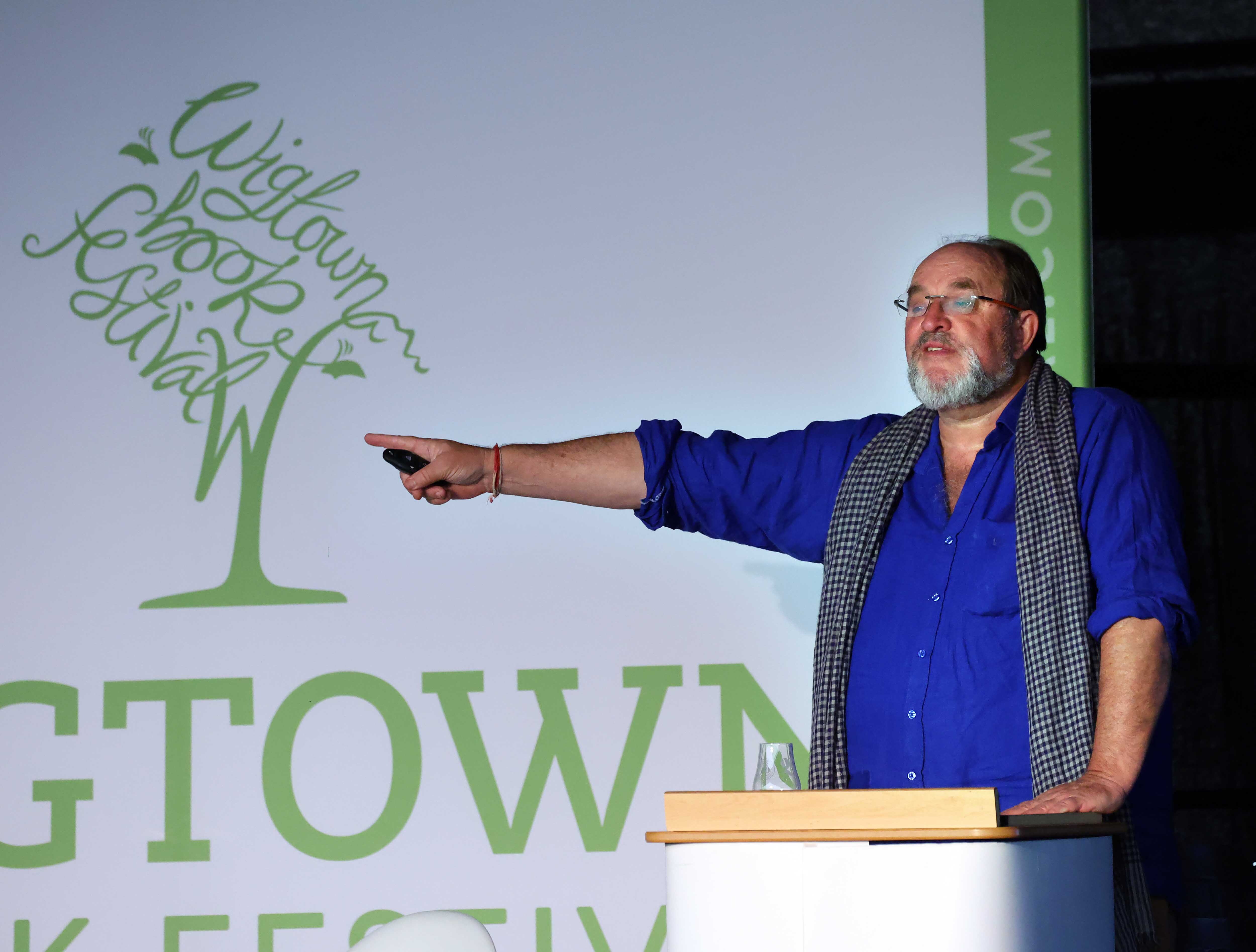 William Dalrymple on stage in front of a Wigtown Book Festival banner