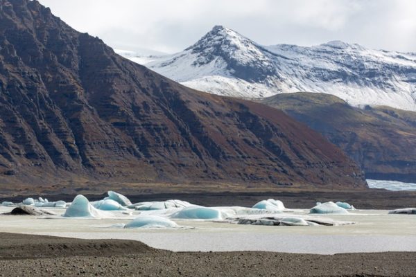 Svinafellsjokull glacier in Iceland. Snow is covering the mountain, Iceburg A68 is melting below due to Global Heating.