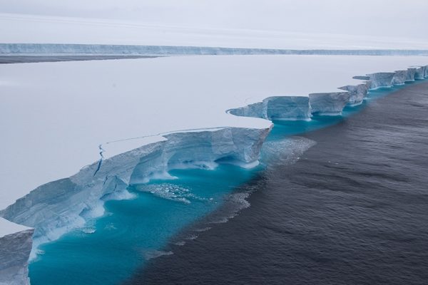 Aeriel view of the A68 Iceburg with turquoise blue water surrounding it.