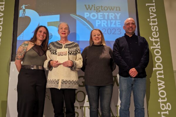 Winners and runners up of Wigtown Poetry Prize 2023 stand on stage. Left to right: Keek Mc, Stephanie Green, Rachel Rankin and Craig Aitchison.