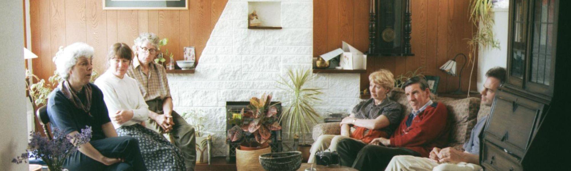 An old photo of a gathering of people at a Wigtown Book Festival event. They are sitting in a room listening to a speaker.